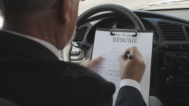 L'homme remplit un CV assis dans une voiture. Recrutement . — Video