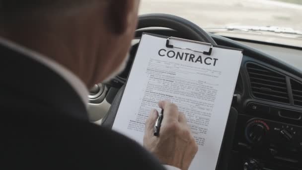 Geschäftsmann liest und unterschreibt Vertrag im Auto. — Stockvideo