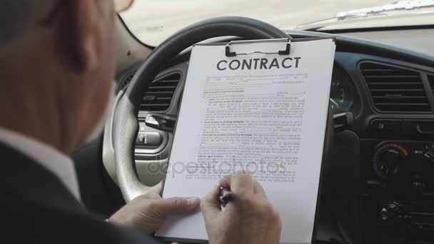 Podnikatel přečte a podepíše smlouvu, zatímco sedí v autě. — Stock video