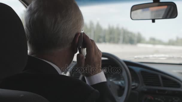 Hombre mayor está hablando en el teléfono móvil en el coche — Vídeos de Stock