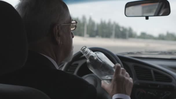 O senhor bebe vodka enquanto está sentado no carro. Motorista bêbado . — Vídeo de Stock