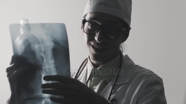 Drunk doctor makes a diagnosis. A medical worker drinks vodka. — Stock Video