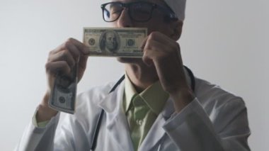 Doktor bir 100 dolarlık banknot öper. Tıbbi bir işçi için rüşvet. Pahalı ilaç.
