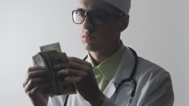 Dokter telt het geld. Smeergeld aan een medisch-werker. Dure geneeskunde. — Stockvideo