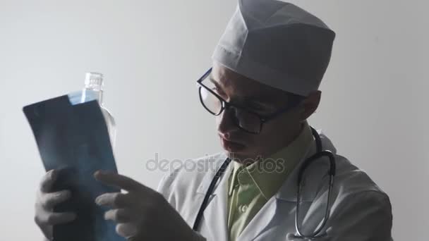 Un dottore ubriaco fa una diagnosi. Un operatore medico beve vodka . — Video Stock