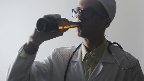 Ritratto di dottore ubriaco. Un operatore medico beve birra . — Video Stock