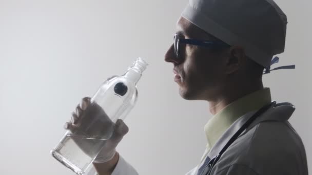 Porträtt av full läkare. En medicinsk arbetare dricker vodka. — Stockvideo