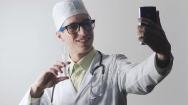 Doktor bir smartphone kullanarak bir selfie yapıyor. Tıbbi işçi kendisi fotoğraf arşivi.