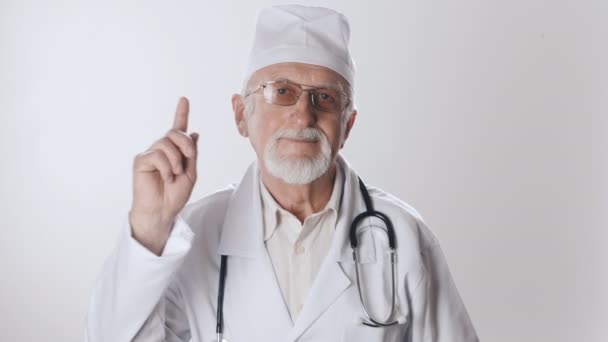 Ένας έμπειρος ηλικιωμένος γιατρός με γένια και γυαλιά απαγορεύει κουνώντας το δάχτυλο. Ιατρική προφυλάξεις — Αρχείο Βίντεο
