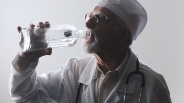 Ritratto di dottore ubriaco. Un operatore medico beve vodka . — Video Stock