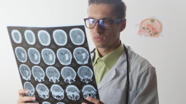 Нейрохирург смотрит на магнитно-резонансную томографию мозга — стоковое видео