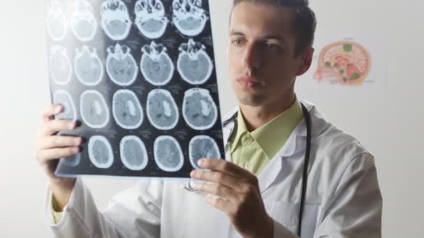 Een neurochirurg arts kijkt met een momentopname van de Magnetic resonance imaging-Mri van de hersenen — Stockvideo