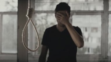 İntihar. Depresif adam döngü arka plan üzerinde boyun için ağlıyor.