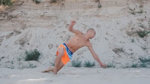 Hombre saltando acrobático truco en verano en la playa al atardecer. Freerunner saltar corcho . — Vídeos de Stock