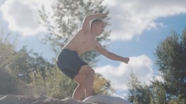 Adam Tek Kişilik sideflip gün batımında sahilde atlama. Freerunner atlama akrobatik dublör