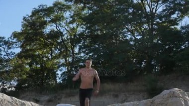 Adam sideflip gün batımında sahilde atlama. Freerunner atlama akrobatik dublör