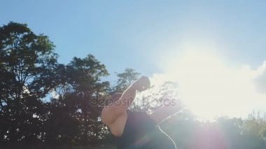 Adam yavaş gün batımında sahilde Backflip atlama
