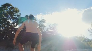 Adam slowmotion batımında sahilde Backflip atlama