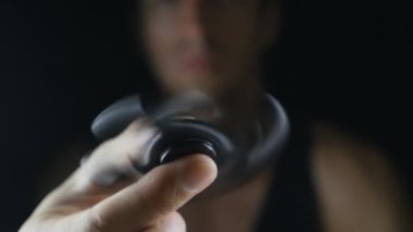 El altında siyah arka plan üzerinde dönen değer değişimi veya Kıpırdanmayı el oyuncak yakından mans