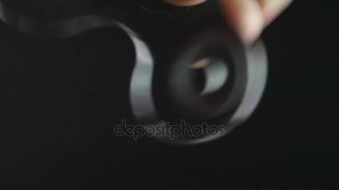 El altında siyah arka plan üzerinde dönen değer değişimi veya Kıpırdanmayı el oyuncak yakından mans