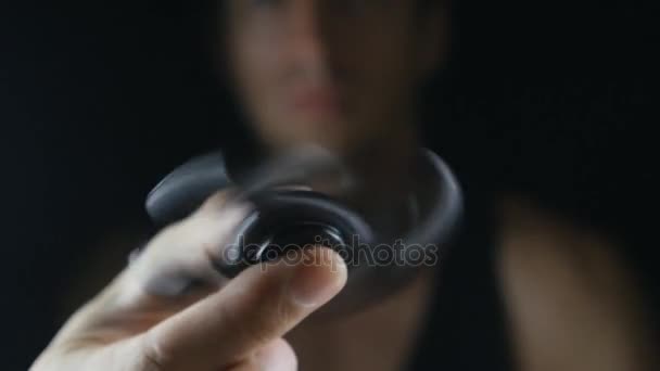 Close-up spinner of friemelen hand speelgoed draaien op mans hand op zwarte achtergrond — Stockvideo