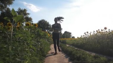 Güzel kız sabah gün doğarken alanında koşu yapıyor. açık havada fitness. Steadicam ile vurdu