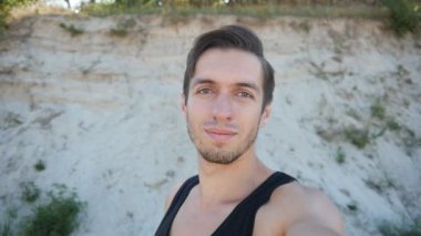 Yaz aylarında sahilde selfie yapan genç erkek