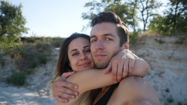 Jeune couple mec et fille faire selfie en été sur la plage au coucher du soleil . — Video