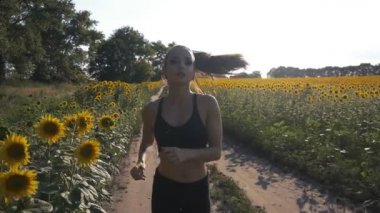 Güzel kız sabah gün doğarken alanında koşu yapıyor. açık havada fitness. Steadicam ile vurdu