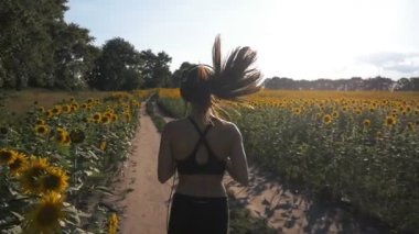 Güzel koşucu kız alanın karşısındaki çalışır. O kulaklıklar müzik dinler.