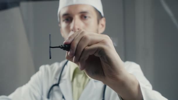 Человек врач пишет слово "здоровье" на стеклянной доске — стоковое видео