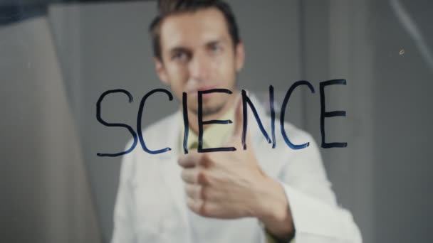 De wetenschapper schrijft het woord "wetenschap" op het glas — Stockvideo