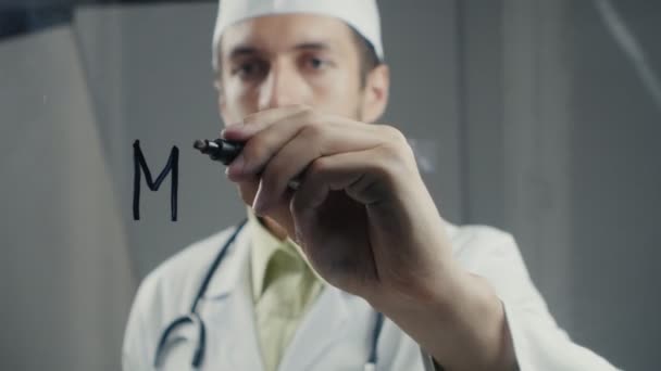 Muž lékař zapíše slovo "lék" na tabuli skla — Stock video