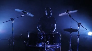 Davulcu Sahne Alanı'nda ayarla davul çalıyor. Ağır çekimde vurdu. Müzik video punk, ağır metal veya rock grubu.