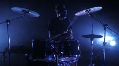 Davulcu Sahne Alanı'nda ayarla davul çalıyor. Ağır çekimde vurdu. Müzik video punk, ağır metal veya rock grubu.