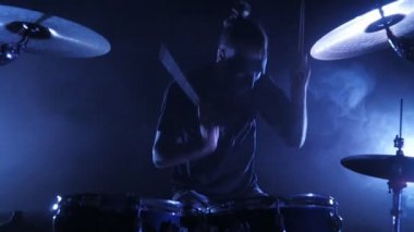 Davulcu Sahne Alanı'nda ayarla davul çalıyor. Ağır çekimde vurdu. Müzik video punk, ağır metal veya rock grubu.