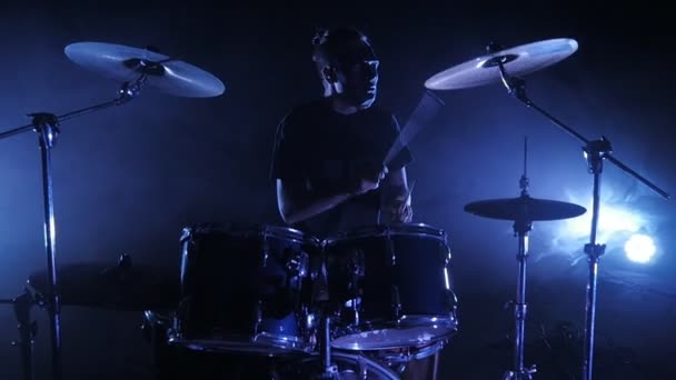 Bubeník hraje bubnu na vymezené ploše. Zastřelen v pomalém pohybu. Hudební video punk, heavy metal nebo rock skupina. — Stock video