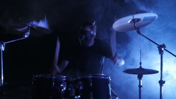 De drummer van masker speelt de trommel die is ingesteld in het werkgebied. Schot in een slowmotion. Videoclip punk, heavy metal of rockgroep. — Stockvideo