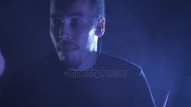 Genç bir erkek davulcu davulunun üstündeki oynamaya yakın çekim ayarlayın. Müzik video punk, ağır metal veya rock grubu.