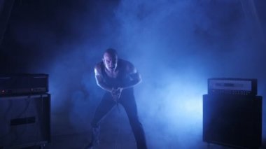 Erkek vokalist mikrofona doğru söylüyor. Şarkıcı sanatçı sahnede konser rock bant. Müzik video punk, ağır metal veya rock grubu