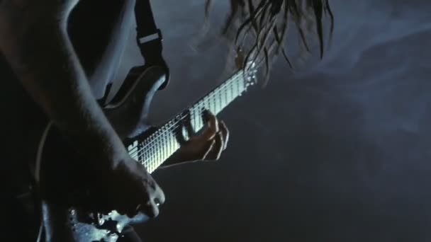 Roqueiro guitarrista com dreadlocks tocando guitarra elétrica no palco. Performance music vídeo rock, punk, heavy metal band . — Vídeo de Stock