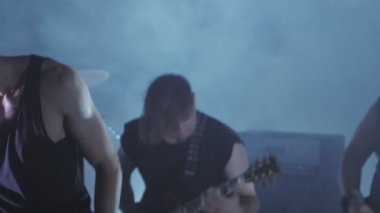 Konser rock grubu solisti, gitarist ve baterist ile sahnede performans. Müzik video punk, ağır metal veya rock grubu.