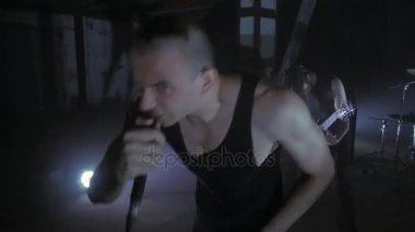 Konser rock grubu solisti, gitarist ve baterist ile sahnede performans. Müzik video punk, ağır metal veya rock grubu.