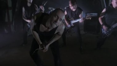 Konser rock grubu solisti, gitarist ve baterist ile sahnede performans. Müzik video punk, ağır metal veya rock grubu.
