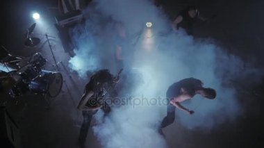 Konser rock grubu solisti, gitarist ve baterist ile sahnede performans. Müzik video punk, ağır metal veya rock grubu.