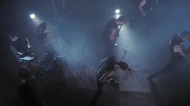 Konser rock grubu solisti, gitarist ve baterist ile sahnede performans. Müzik video punk, ağır metal veya rock grubu.