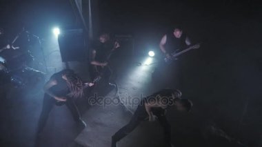 Konser rock grubu solisti, gitarist ve baterist ile sahnede performans. Müzik video punk, ağır metal veya rock grubu.