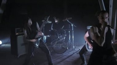 Konser rock grubu solisti, gitarist ve baterist ile sahnede performans. Müzik video punk, ağır metal veya rock grubu.