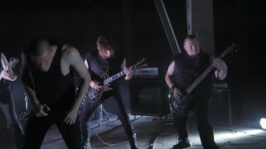 Konser rock grubu solisti, gitarist ve baterist ile sahnede performans. Müzik video punk, ağır metal veya rock grubu.