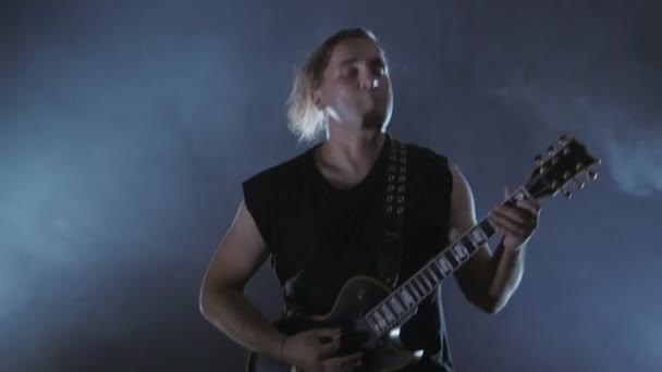 Brutal male rocker plays the electric guitar. Music video punk, heavy metal or rock group. — Stock Video